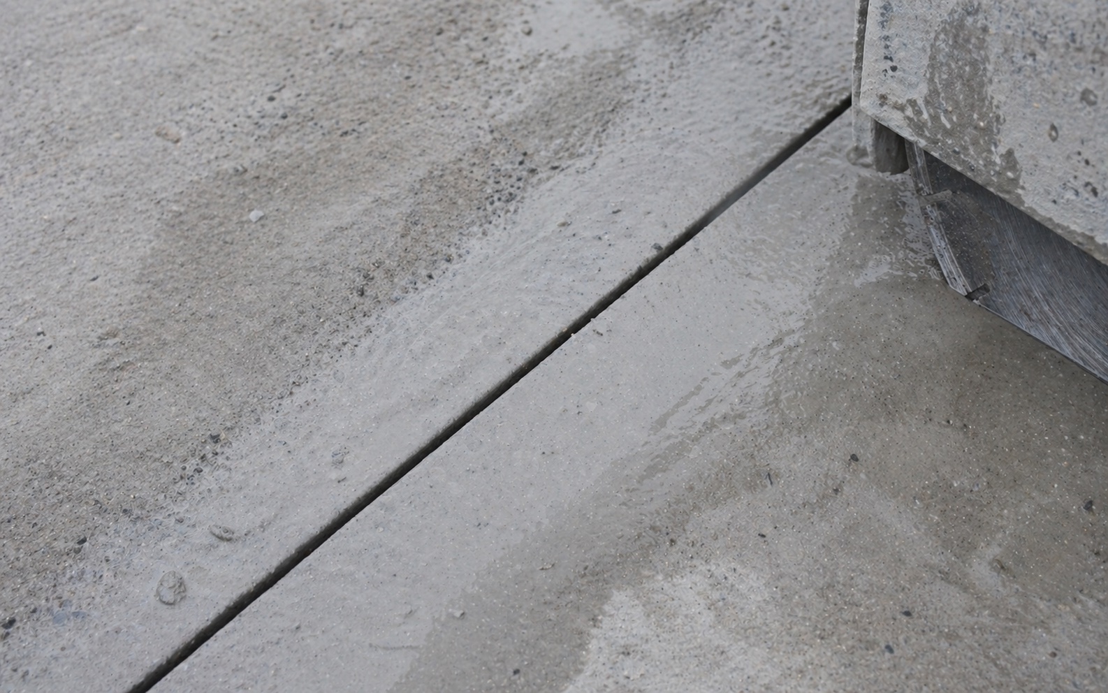 Clean saw cut line through a concrete slab with the saw blade just out of frame